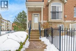 Snow covered property entrance featuring brick siding -