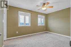 Empty room with light carpet and ceiling fan -