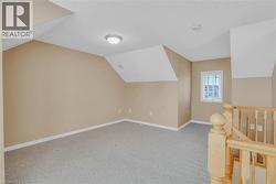 Bonus room featuring light carpet, vaulted ceiling, and a textured ceiling -