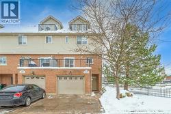 View of front of home with a balcony, brick siding, driveway, and an attached garage -