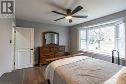 Bedroom featuring dark wood-style flooring and ceiling fan -