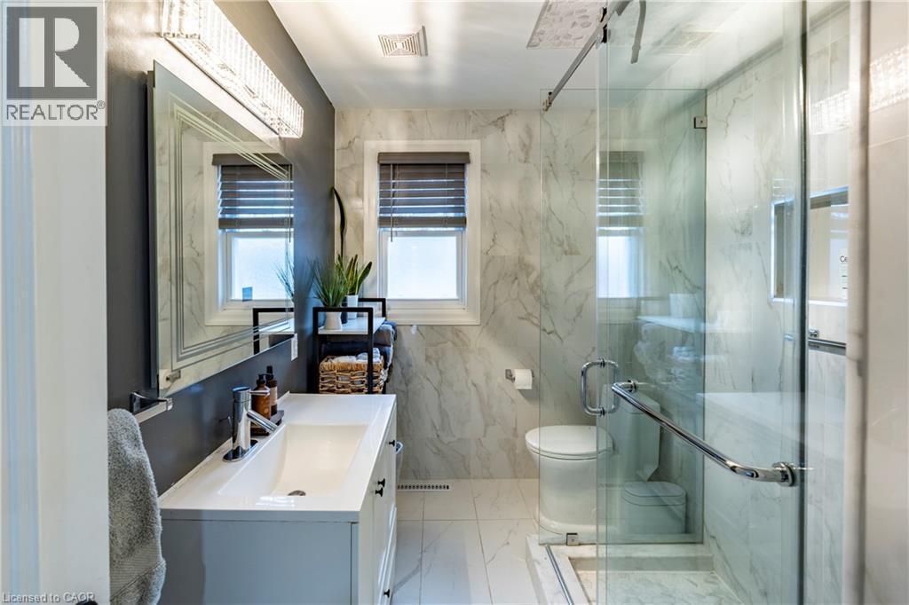 Full bathroom featuring vanity, light marble finish floors, a marble finish shower, and tile walls - 266 Melrose Avenue, Kitchener, ON - Indoor Photo Showing Bathroom