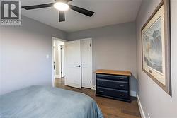 Bedroom with dark wood-type flooring and ceiling fan -