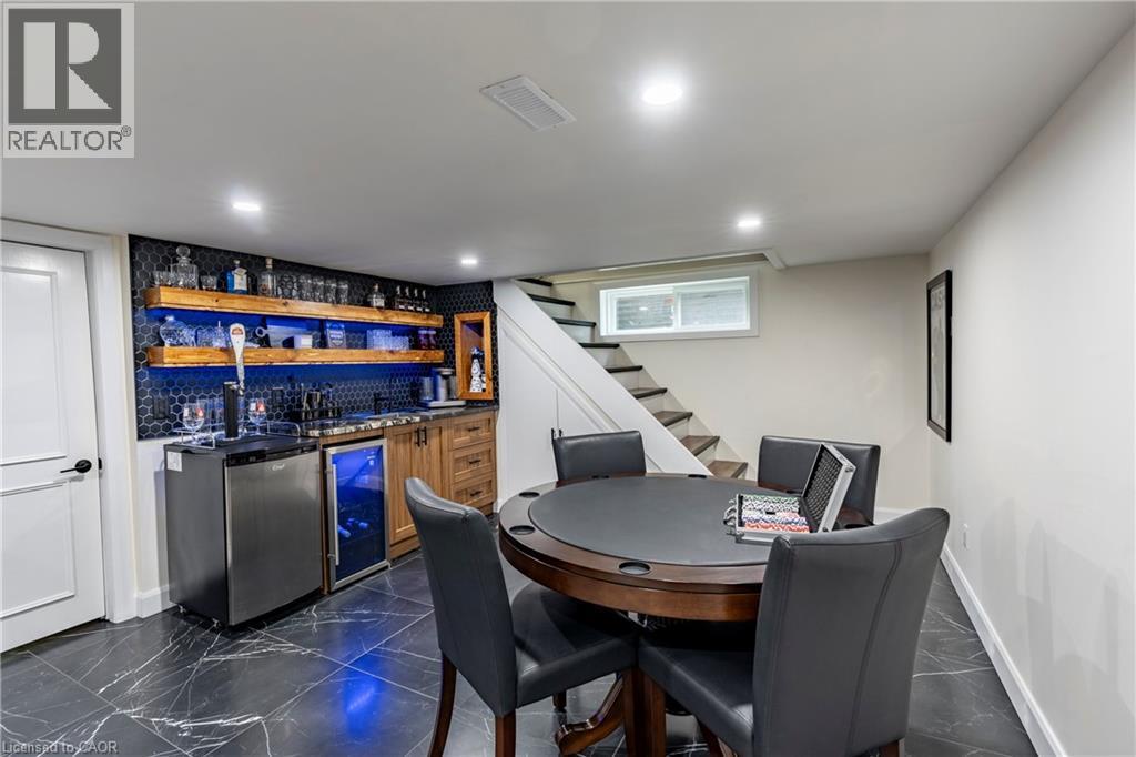 Indoor wet bar featuring dark countertops, open shelves, dark marble finish flooring, wine cooler, and stairs - 266 Melrose Avenue, Kitchener, ON - Indoor