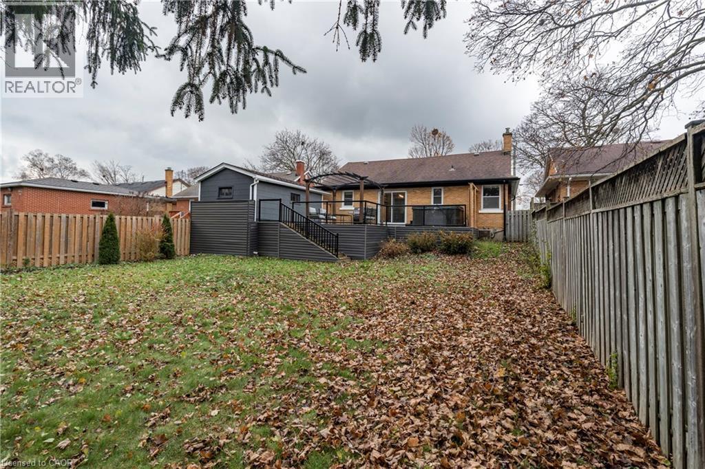 Back of house featuring a deck, a fenced backyard, brick siding, and a chimney - 266 Melrose Avenue, Kitchener, ON - Outdoor