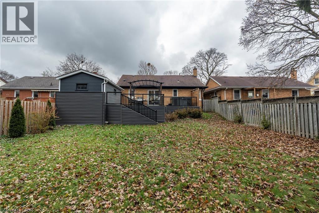 Rear view of house with a fenced backyard, a deck, stairs, and brick siding - 266 Melrose Avenue, Kitchener, ON - Outdoor