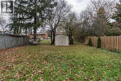 Fenced backyard featuring a storage shed -