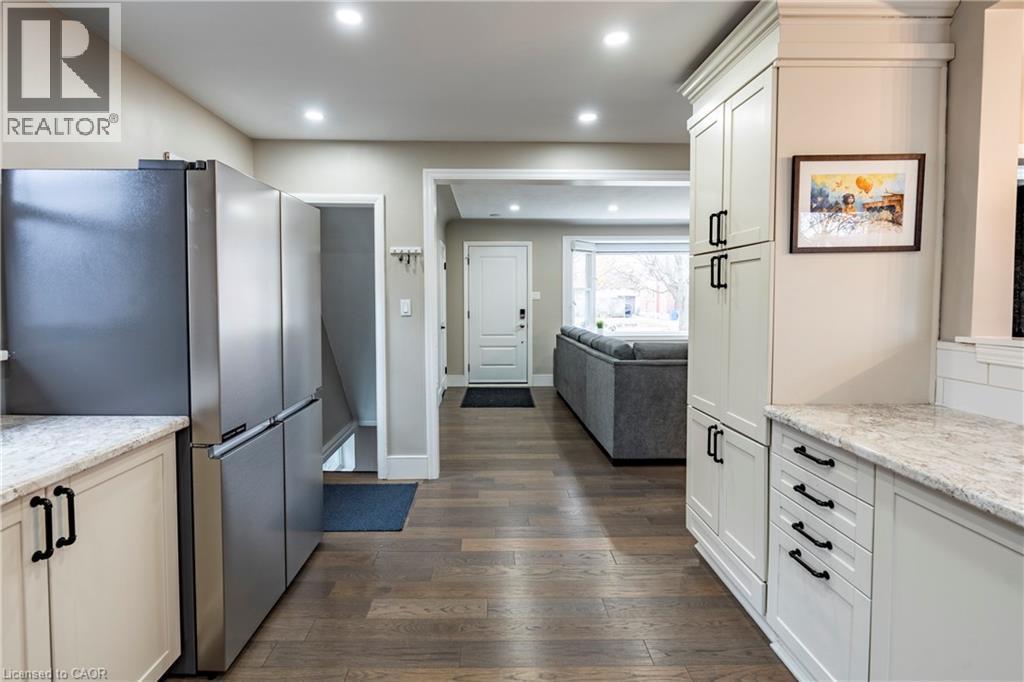Kitchen featuring freestanding refrigerator, light stone counters, dark wood finished floors, open floor plan, and recessed lighting - 266 Melrose Avenue, Kitchener, ON - Indoor Photo Showing Kitchen