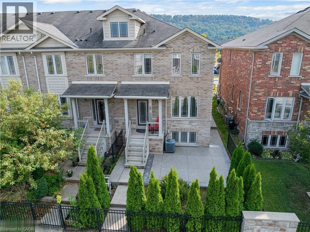 View of front of house featuring a shingled roof, brick siding, a patio, and stairs - 6 Chestnut Drive Unit# 16, Grimsby, ON - Outdoor With Facade