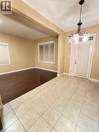 Entrance foyer featuring light tile patterned flooring and baseboards -