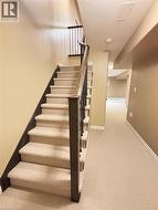 Staircase featuring a textured ceiling and carpet floors -