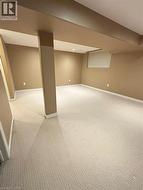 Finished below grade area featuring carpet flooring and baseboards -