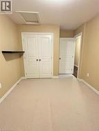 Unfurnished bedroom featuring attic access, a textured ceiling, a closet, and light carpet -