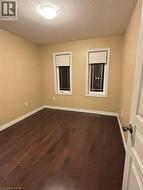 Empty room featuring a textured ceiling and dark wood-style floors -