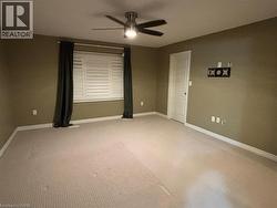 Spare room with a ceiling fan and light colored carpet -
