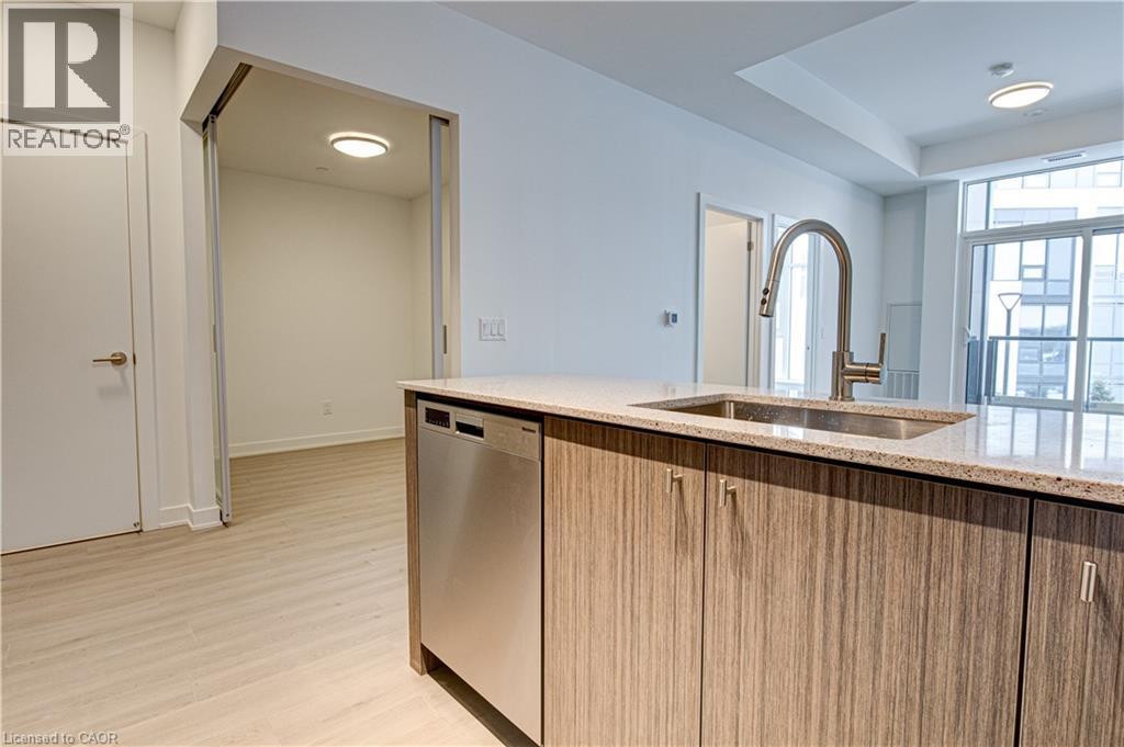Kitchen featuring light stone countertops, stainless steel dishwasher, light wood finished floors, and light brown cabinetry - 25 Wellington Street A S Unit# 209, Kitchener, ON - Indoor Photo Showing Kitchen