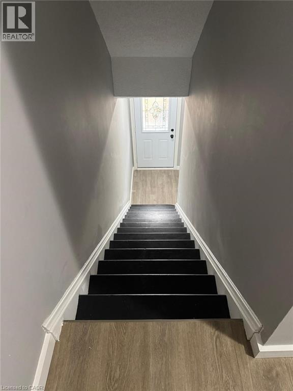 Stairway featuring wood finished floors and baseboards - 316 Dufferin Street, Stratford, ON - Indoor Photo Showing Other Room