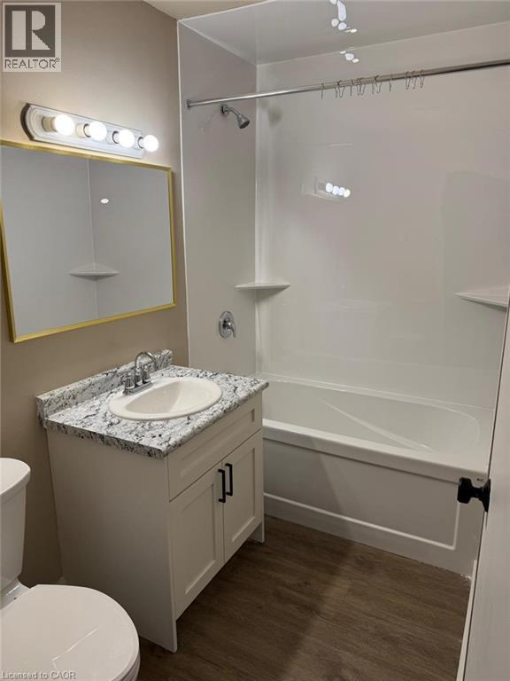 Bathroom featuring vanity, shower / bath combination, and dark wood finished floors - 316 Dufferin Street, Stratford, ON - Indoor Photo Showing Bathroom