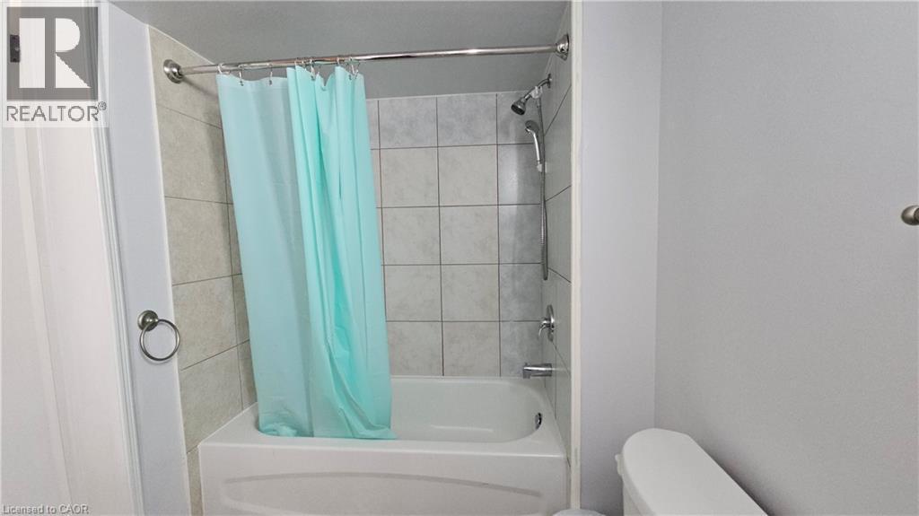 Bathroom featuring shower / bathtub combination with curtain and toilet - 10 Doll Court, Kitchener, ON - Indoor Photo Showing Bathroom