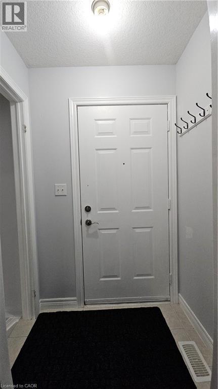 Doorway to outside with a textured ceiling and tile patterned flooring - 10 Doll Court, Kitchener, ON - Indoor Photo Showing Other Room