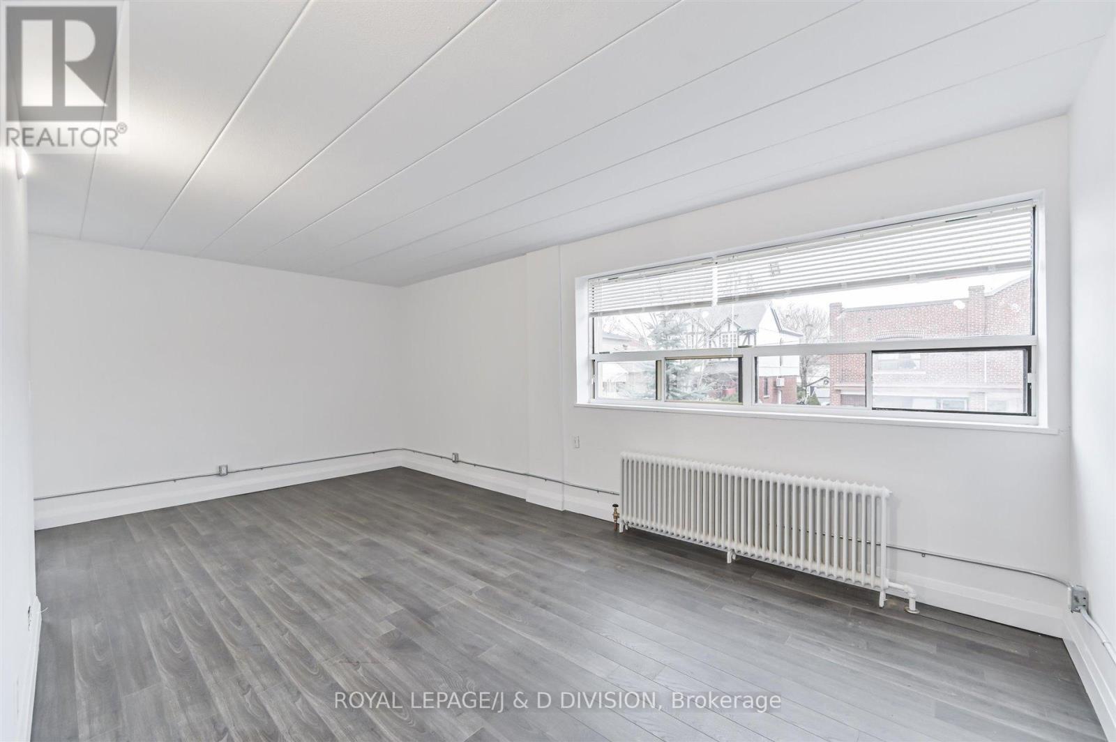 Living Room w extra-wide window - 201 - 325 Sammon Avenue, Toronto, ON - Indoor Photo Showing Other Room