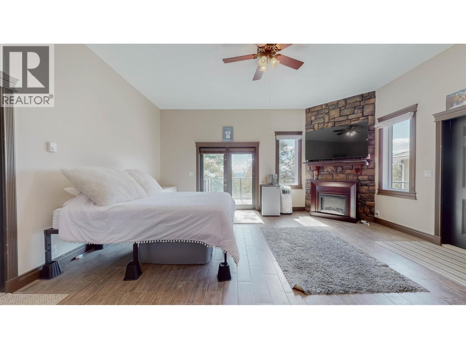1370 Bullmoose Way, Osoyoos, BC - Indoor Photo Showing Bedroom With Fireplace