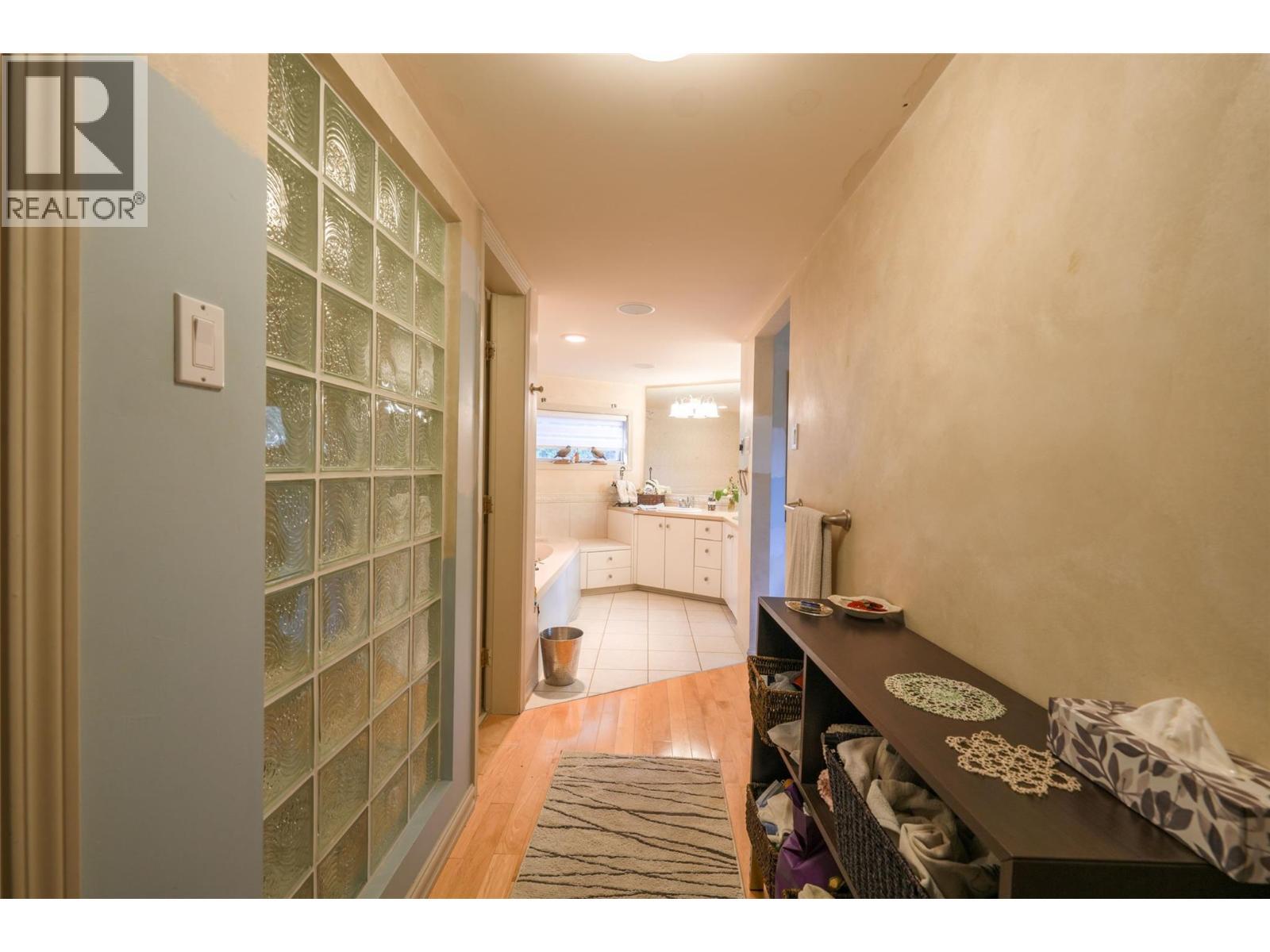 Primary suite a few steps up from Foyer entrance - 14038 Ponderosa Way, Coldstream, BC - Indoor Photo Showing Other Room