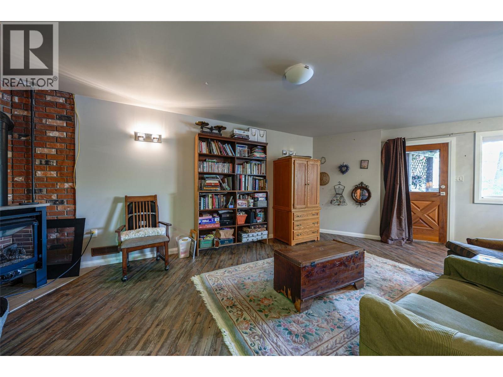 Basement Family Room with freestanding gas F/P - 14038 Ponderosa Way, Coldstream, BC - Indoor Photo Showing Living Room With Fireplace