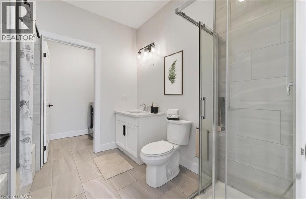 Bathroom with a stall shower, vanity, and washer / dryer - 7 South Court Street W, Norwich, ON - Indoor Photo Showing Bathroom