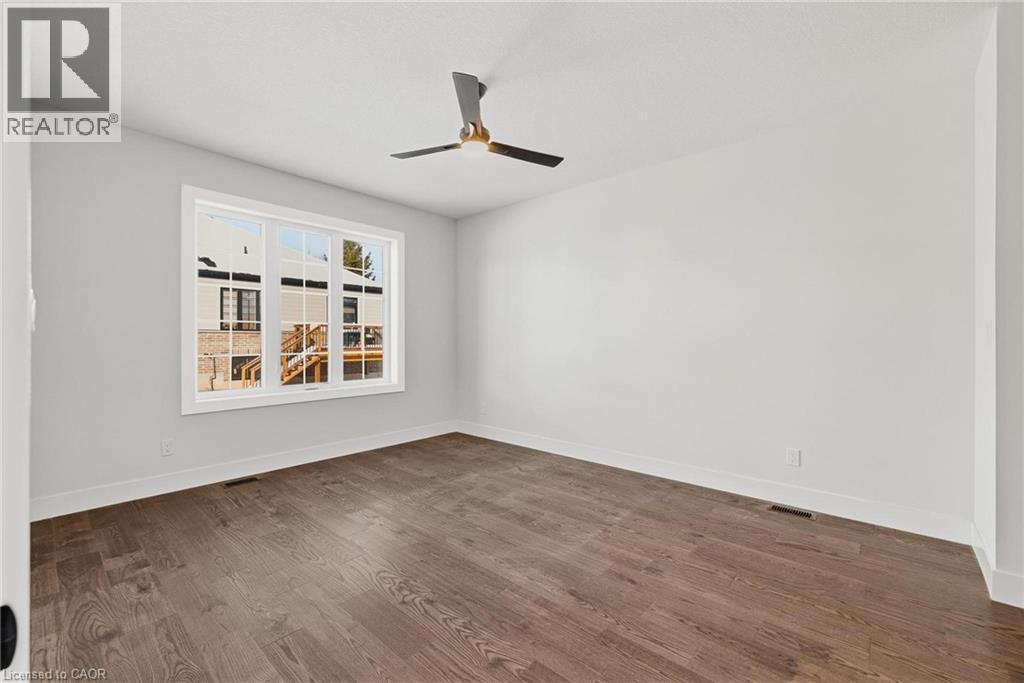 Empty room featuring dark wood-style flooring and a ceiling fan - 4 Elgin Street W, Norwich, ON - Indoor Photo Showing Other Room