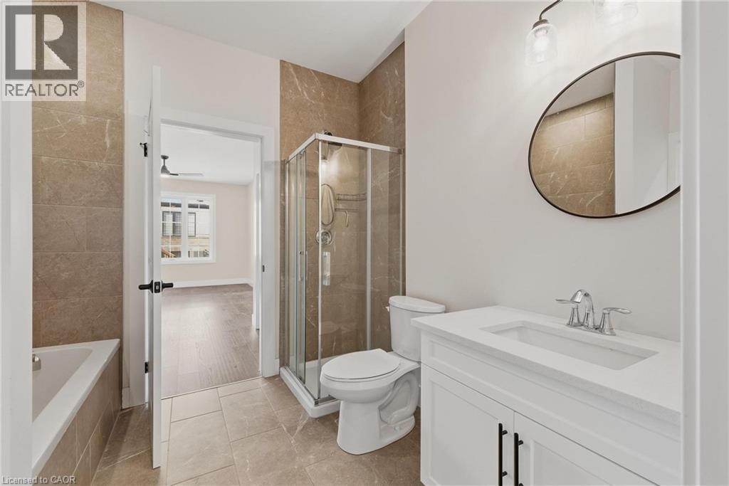 Full bath featuring a garden tub, a stall shower, vanity, and light tile patterned floors - 4 Elgin Street W, Norwich, ON - Indoor Photo Showing Bathroom