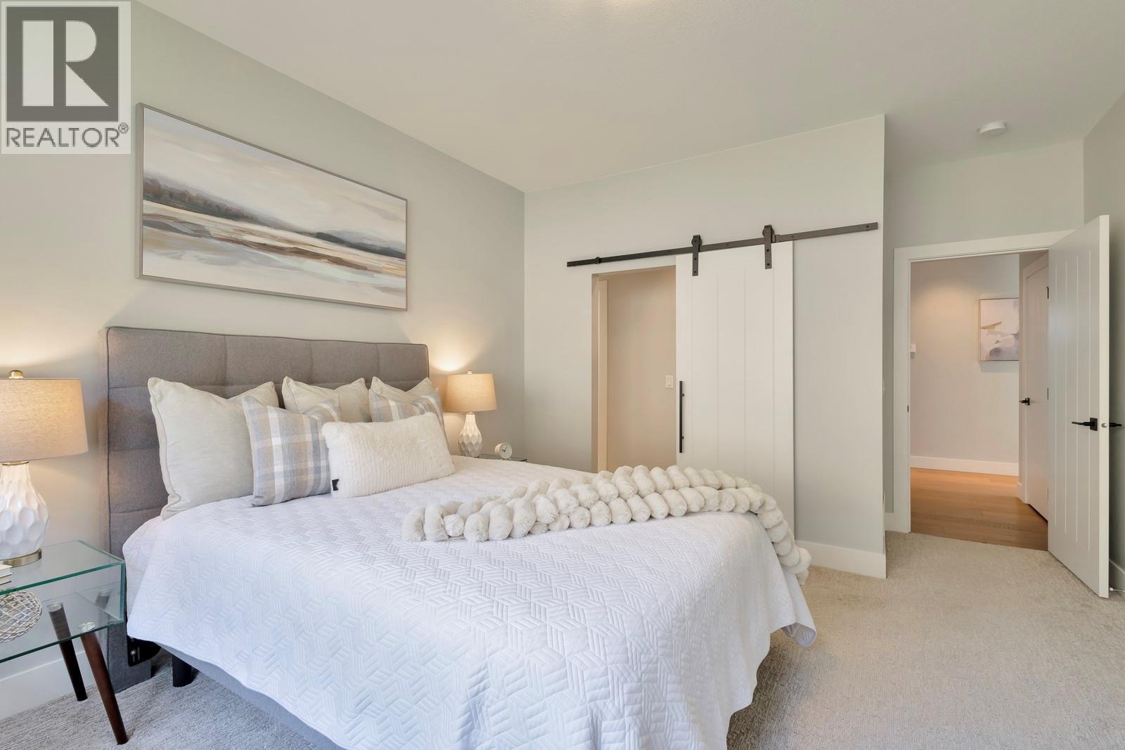 Barn door leads to large walk-in closet & ensuite - 2594 Crown Crest Drive, West Kelowna, BC - Indoor Photo Showing Bedroom
