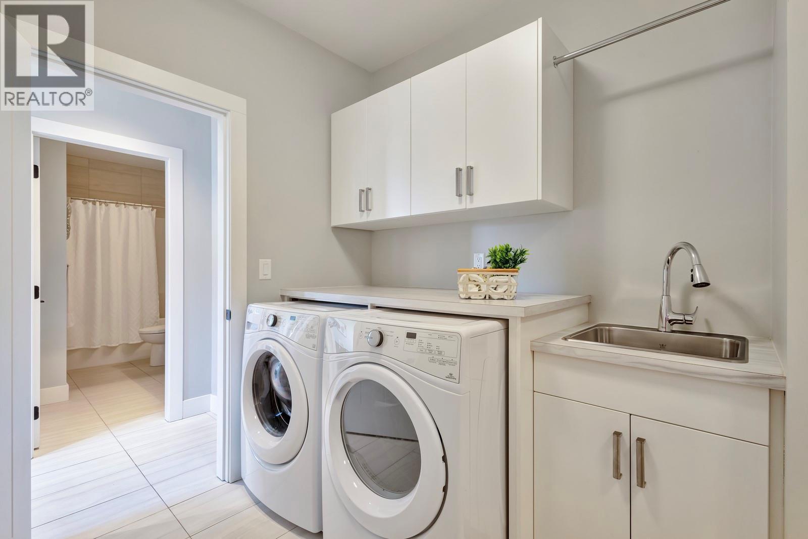 Large laundry room with lots of cabinetry & storage - 2594 Crown Crest Drive, West Kelowna, BC - Indoor Photo Showing Laundry Room
