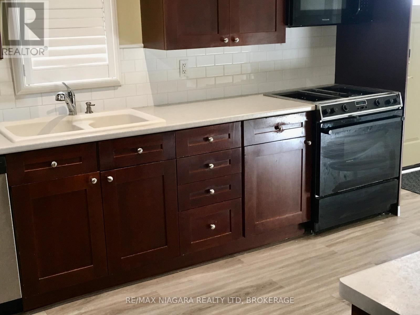 Gas Stove and over Range Microwave - 4576 Kalar Road, Niagara Falls (Ascot), ON - Indoor Photo Showing Kitchen With Double Sink