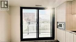 Kitchen with stainless steel microwave, light brown cabinetry, a city view, and dark wood finished floors -
