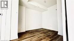 Spare room featuring dark wood-type flooring and baseboards -