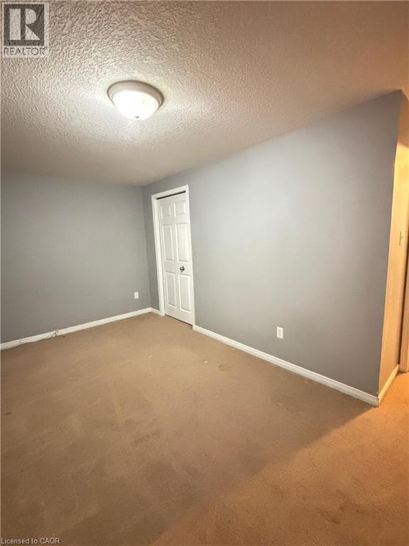 Spare room featuring carpet flooring and a textured ceiling - 50 Howe Drive Unit# 12A, Kitchener, ON - Indoor Photo Showing Other Room