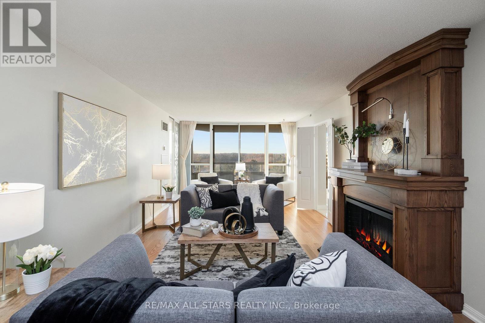 Living room w electric fireplace and pond view. - 611 - 610 Bullock Drive, Markham, ON - Indoor Photo Showing Living Room With Fireplace