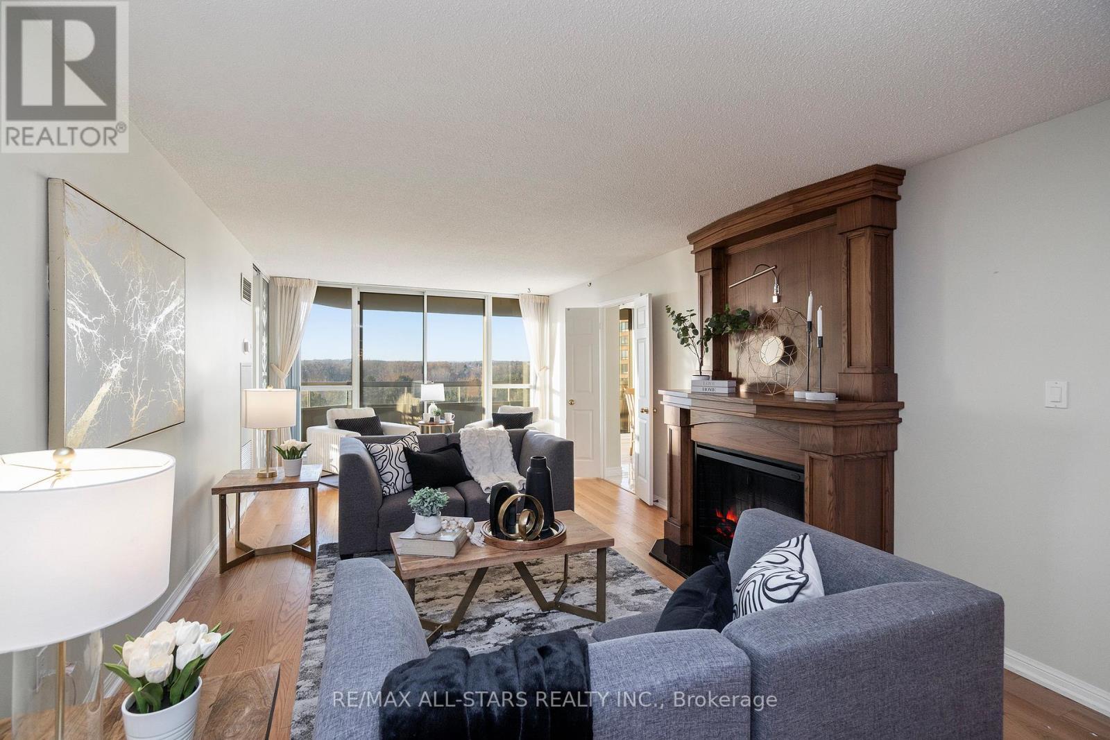 Walk out to balcony w pond view - 611 - 610 Bullock Drive, Markham, ON - Indoor Photo Showing Living Room With Fireplace