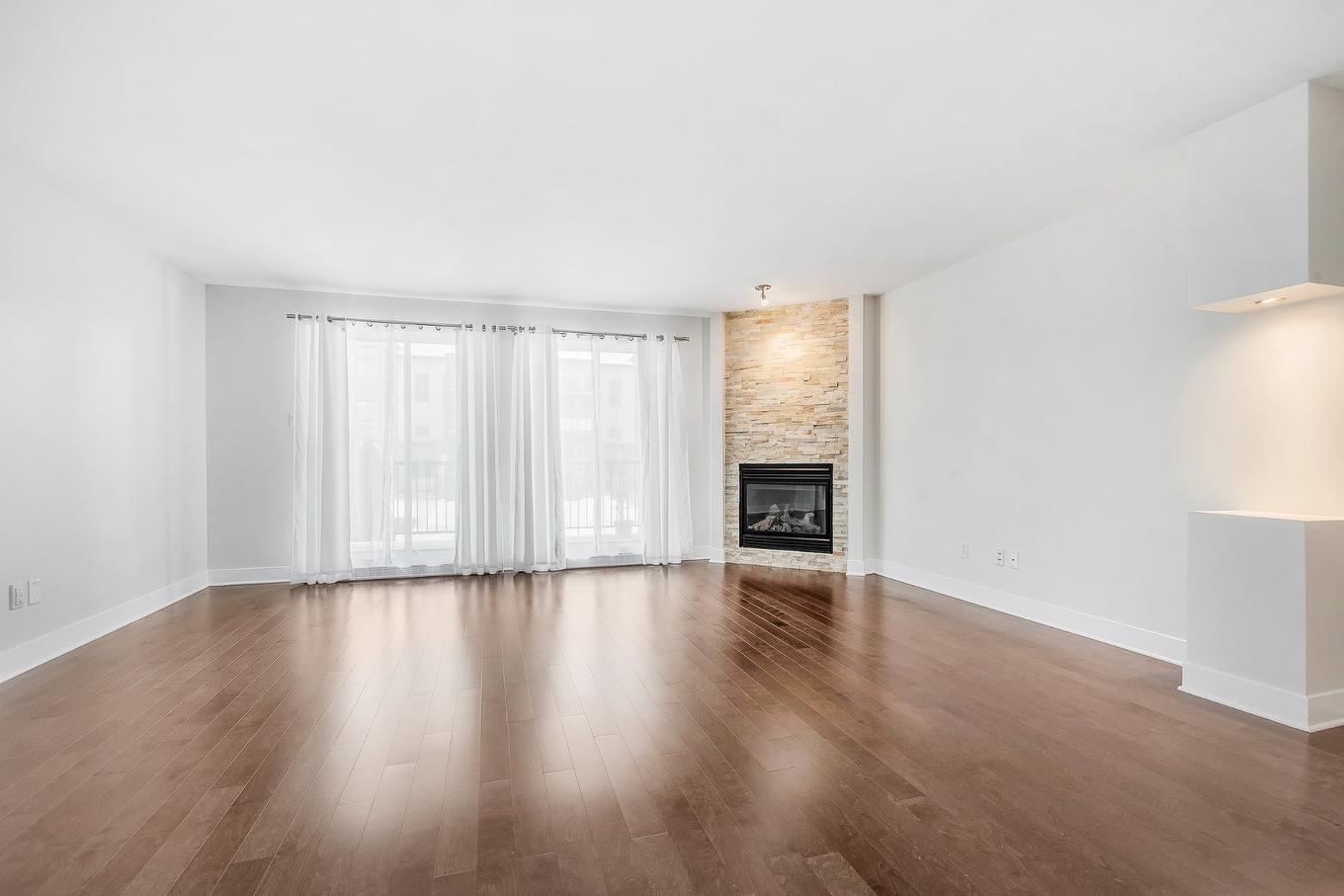 Living room - 201-691 Mtée Des Pionniers, Terrebonne (Lachenaie), QC - Indoor Photo Showing Living Room With Fireplace