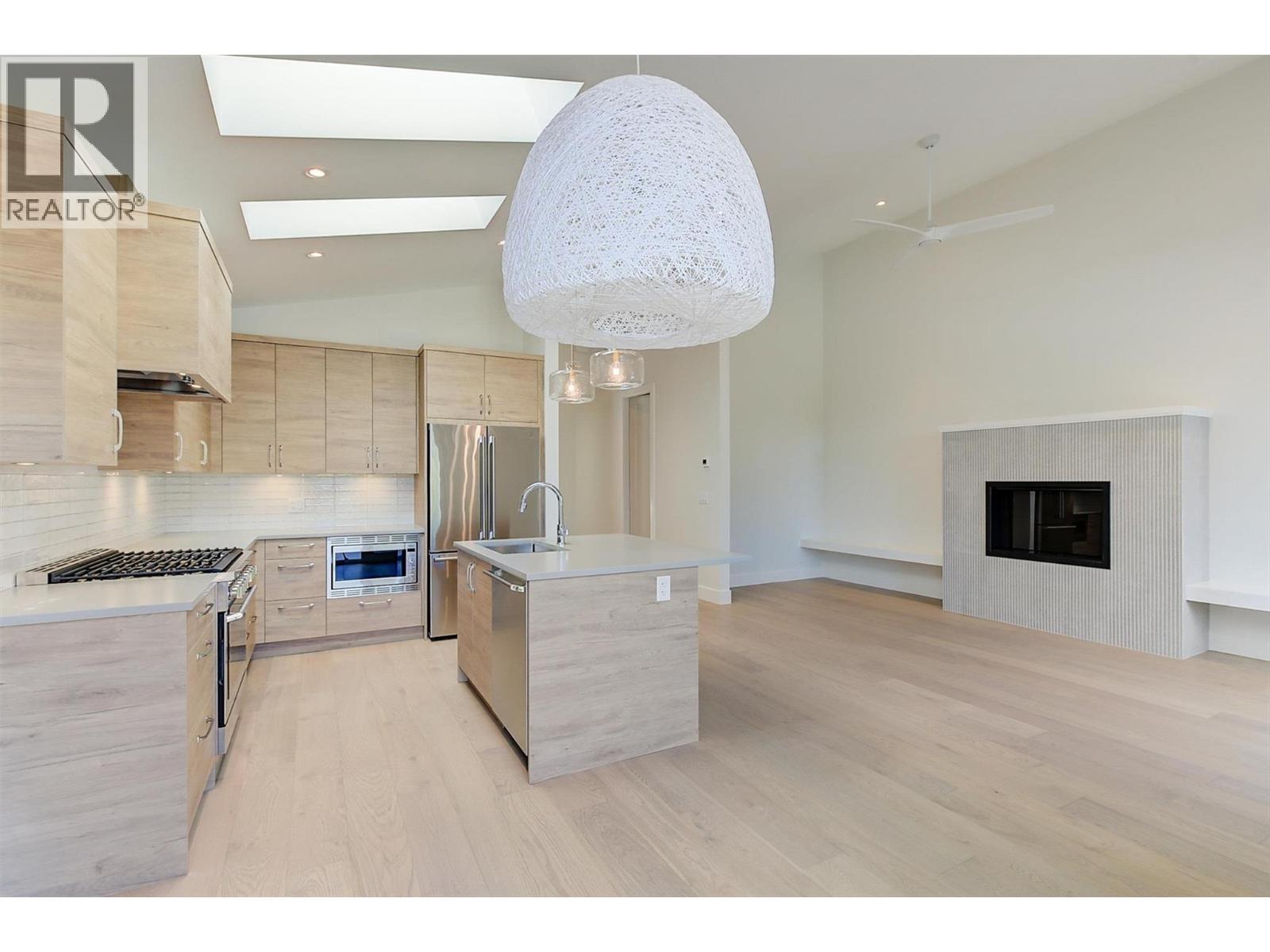 Open concept living room with electric fireplace - 761 Barnaby Road, Kelowna, BC - Indoor Photo Showing Kitchen