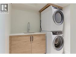 Stackable washer and dryer with a laundry sink for convenience -