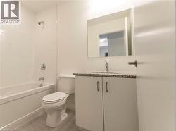 Bathroom featuring tub / shower combination, vanity, and light tile patterned floors -
