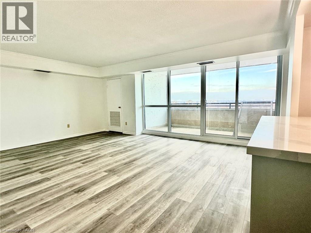 Unfurnished living room featuring light wood-style floors and a textured ceiling - 389 Dundas Street Unit# 1506, London, ON - Indoor Photo Showing Other Room