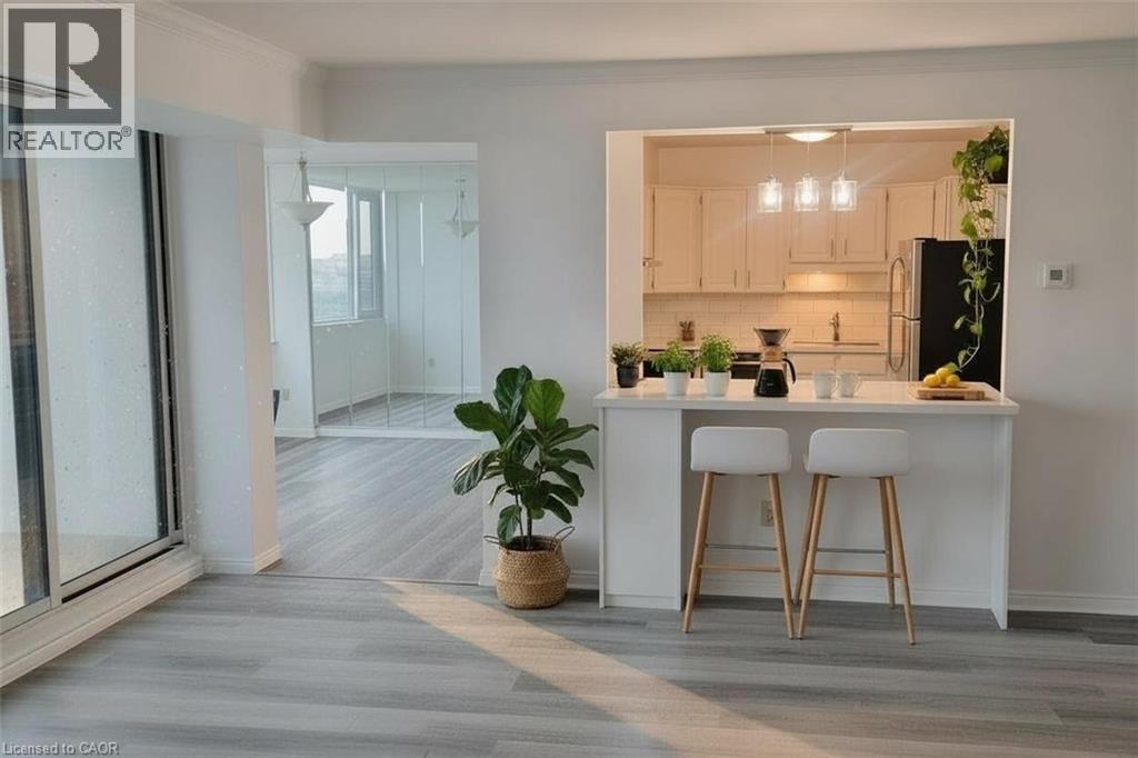 Kitchen with a breakfast bar area, freestanding refrigerator, light countertops, tasteful backsplash, and ornamental molding - 389 Dundas Street Unit# 1506, London, ON - Indoor