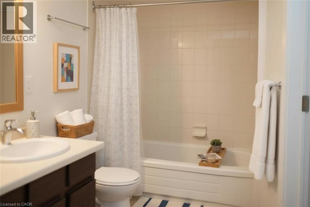 Bathroom featuring vanity and shower / bath combo with shower curtain - 389 Dundas Street Unit# 1506, London, ON - Indoor Photo Showing Bathroom