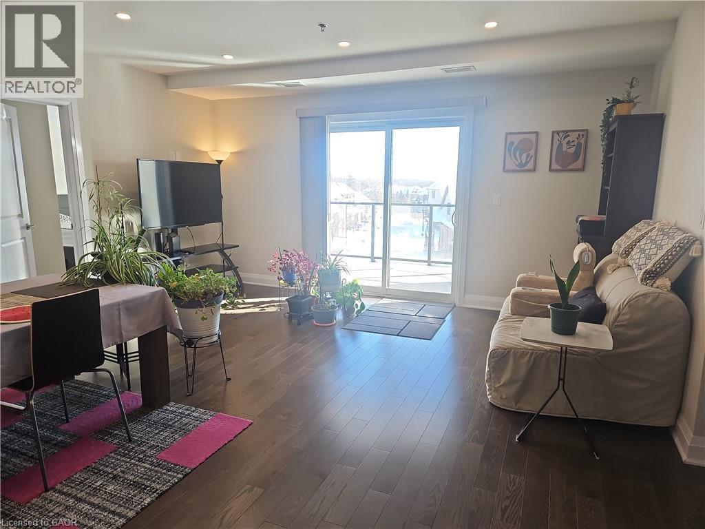 Living area featuring dark wood finished floors and recessed lighting - 249 Grey Silo Road Unit# 301, Waterloo, ON - Indoor Photo Showing Living Room