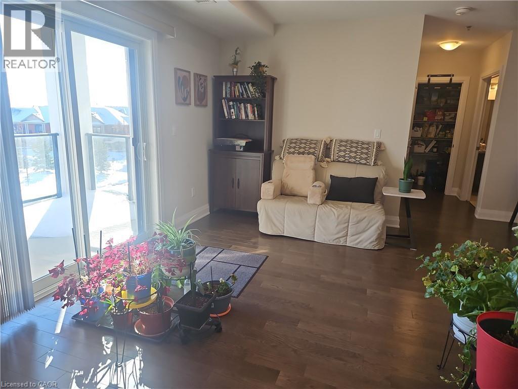 Living area with dark wood finished floors and baseboards - 249 Grey Silo Road Unit# 301, Waterloo, ON - Indoor