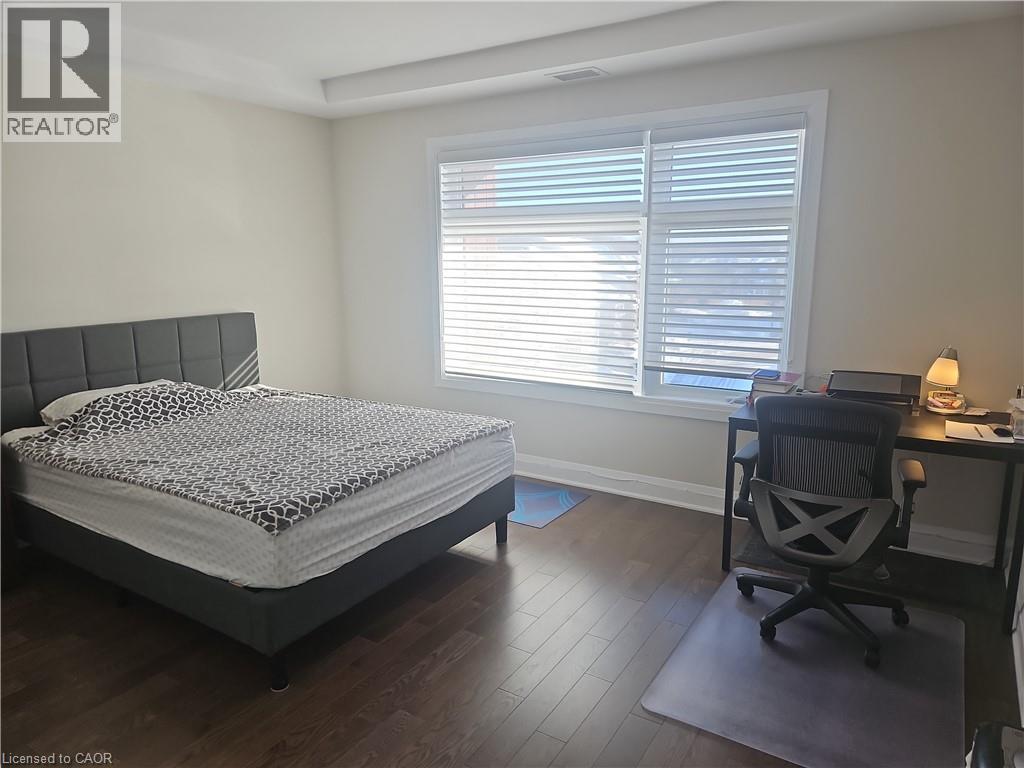 Bedroom with dark wood-type flooring and an office area - 249 Grey Silo Road Unit# 301, Waterloo, ON - Indoor Photo Showing Bedroom