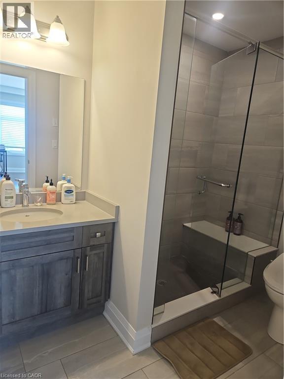 Bathroom featuring light tile patterned floors, vanity, and a shower stall - 249 Grey Silo Road Unit# 301, Waterloo, ON - Indoor Photo Showing Bathroom